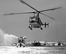 Aircraft Picture - A USAF Huskie aids a practice firefighting operation at Cam Ranh Bay AB, Vietnam in 1968. Note the aircraft's jungle camoflauge paint scheme.