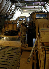 Airplane Picture - Excavators in the rear of a C-5. Loadmasters must ensure cargo is secured and weight distribution is balanced before takeoff.