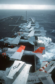 Airplane Picture - S-3A Viking, A-6E Intruder, and an EA-6B Prowler aircraft are parked on the flight deck of the aircraft carrier USS John F. Kennedy (CV-67) during a storm.