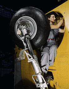 Airplane Picture - This woman worker at the Vultee-Nashville is shown making final adjustments in the wheel well of an inner wing before the installation of the landing gear. (February 1942)