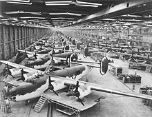 Airplane Picture - B-24 Very Long Range Liberators at the Consolidated-Vultee Plant, Fort Worth, Texas in the foreground with the dark green and white paint scheme. To the rear of this front line are C-87 