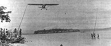 Aircraft Picture - A Piper Cub of the 1st Marine Division’s improvised air force snags a message from a patrol on New Britain's north coast.