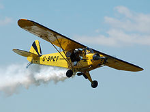 Aircraft Picture - Piper J3C-65 displays at Cotswold Airport, Gloucestershire, England in 2010. This aircraft is part of O'Briens Flying Circus Aerobatic Stunt Team.