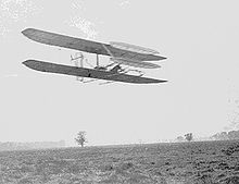 Airplane Picture - Wilbur in FlyerII Circling Huffman Prairie November 1904. The front elevator has been enlarged & the radiator moved to a rear strut since the May photo above.