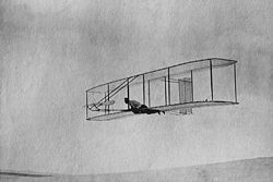 Airplane Picture - The 1902 Wright Glider (Wilbur piloting) on one of its early test flights before replacement of the fixed double rear vertical rudder with a single steerable rudder.