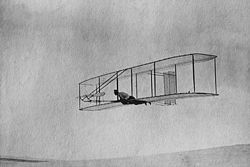 Airplane Picture - The 1902 Wright Glider (Wilbur piloting) on one of its early test flights before replacement of the fixed double rear vertical rudder with a single steerable rudder.