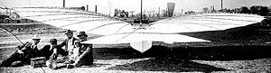 Airplane Picture - Gustave Whitehead and his 1901 monoplane taken near Whitehead's Pine Street shop. His infant daughter, Rose, sits on her father's lap, and the engine that powers the front landing-gear wheels is on the ground in front of the others.