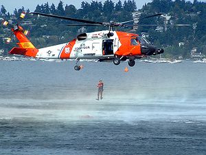 Helicopter Picture - A HH-60J Jayhawk hovering as a USCG rescue swimmer enters the water during a demonstration.