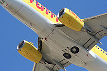 Airplane Picture - Boeing 737-700 showing the retracted landing gear, engine nacelles with flattened underside and triangular shape.