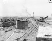 World War 1 Picture - This 1917 photo of the Poperinge yard of the Australian 2nd Light Railway Operating Company shows a water tank car in the right foreground. Behind the tank car is a partially armored, 16-wheel, hand-operated light railway crane capable of lifting 6 tons. The crane was built by Ransomes & Rapier of Ipswich, England. Cars in the left background appear to be loaded with crates of food or ammunition.