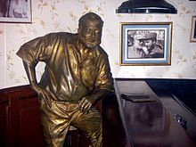 World War 1 Picture - Statue of Hemingway by Jos Villa Soberxn, El Floridita bar in Havana, with a photo of Hemingway awarding Fidel Castro a prize in a fishing contest in 1960 (after the Cuban revolution) on the wall.