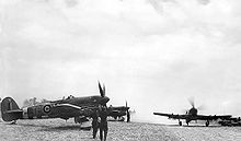 Airplane Picture - 198 Sqn. Typhoons on airfield B.7 Rucqueville-Martragny, France, in July 1944. MN526 TP-V has the larger Tempest tailplane and a four bladed propeller. A heavy dust cloud has been stirred up by the taxiing aircraft.