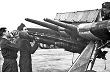 Airplane Picture - Armourers loading RP-3 rockets with 60 lb High Explosive heads onto steel Mk. I rails. The large hinged gun-bay doors are open. The weathered Invasion stripes are on upper and lower wing surfaces, indicating this photo was taken some time in June 1944.