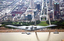 Airplane Picture - B-2 in flight over the Mississippi River (St. Louis, Missouri) with the Gateway Arch and Busch Stadium in the background