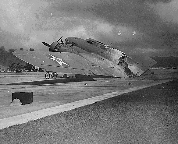 Airplane Pictures - B-17C AAF S/N 40-2074 at Hickam Field. As Capt Raymond T. Swenson landed on 7 Dec 1941, gunfire set alight the flare storage box amidships, burning the plane in two. One crewman was killed by Zero attack. Photo by Tai Sing Loo. Loo's straw helmet is visible in the foreground