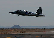 Airplane picture - A civilian F-5B (restored to include a U.S. Air Force paint scheme) flies a low pass down Runway 30 at the Mojave Spaceport