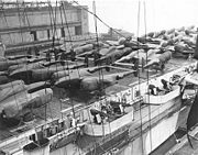 Airplane Pictures - P-38s deck-loaded on CVE, ready for shipment, cocooned against salt, at New York