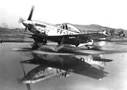 Airplane Pictures - F-51 Mustang taxis through a puddle in Korea, laden with bombs and rockets