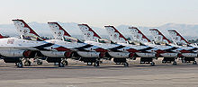 Airplane Picture - Thunderbirds F-16s (including three spare aircraft, for a total of nine) precisely lined up on the ramp at Nellis AFB just prior to the team's last performance of 2004.