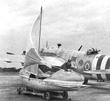 Warbird Picture - A rigged airborne lifeboat in front of a Warwick with D-Day identification stripes.